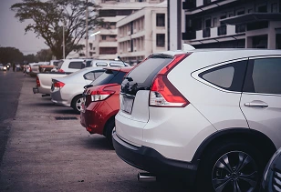 Row of used cars parked in a dealership lot available for purchase and export.